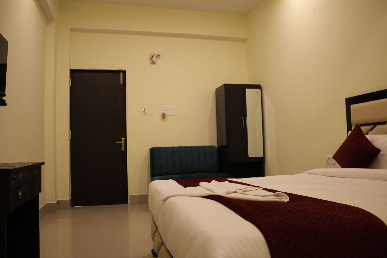 Een hotelkamer met een bed, een bureau, een kledingkast en een deur.
