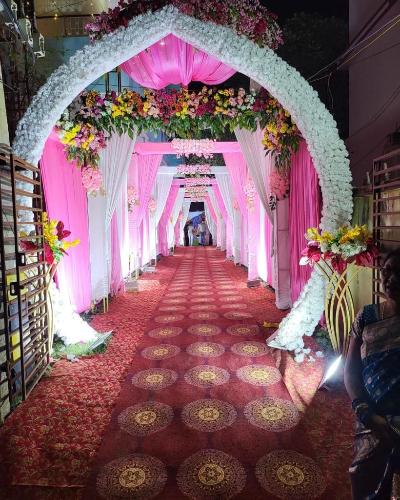 Un pasillo interior con alfombra roja y decoración floral.