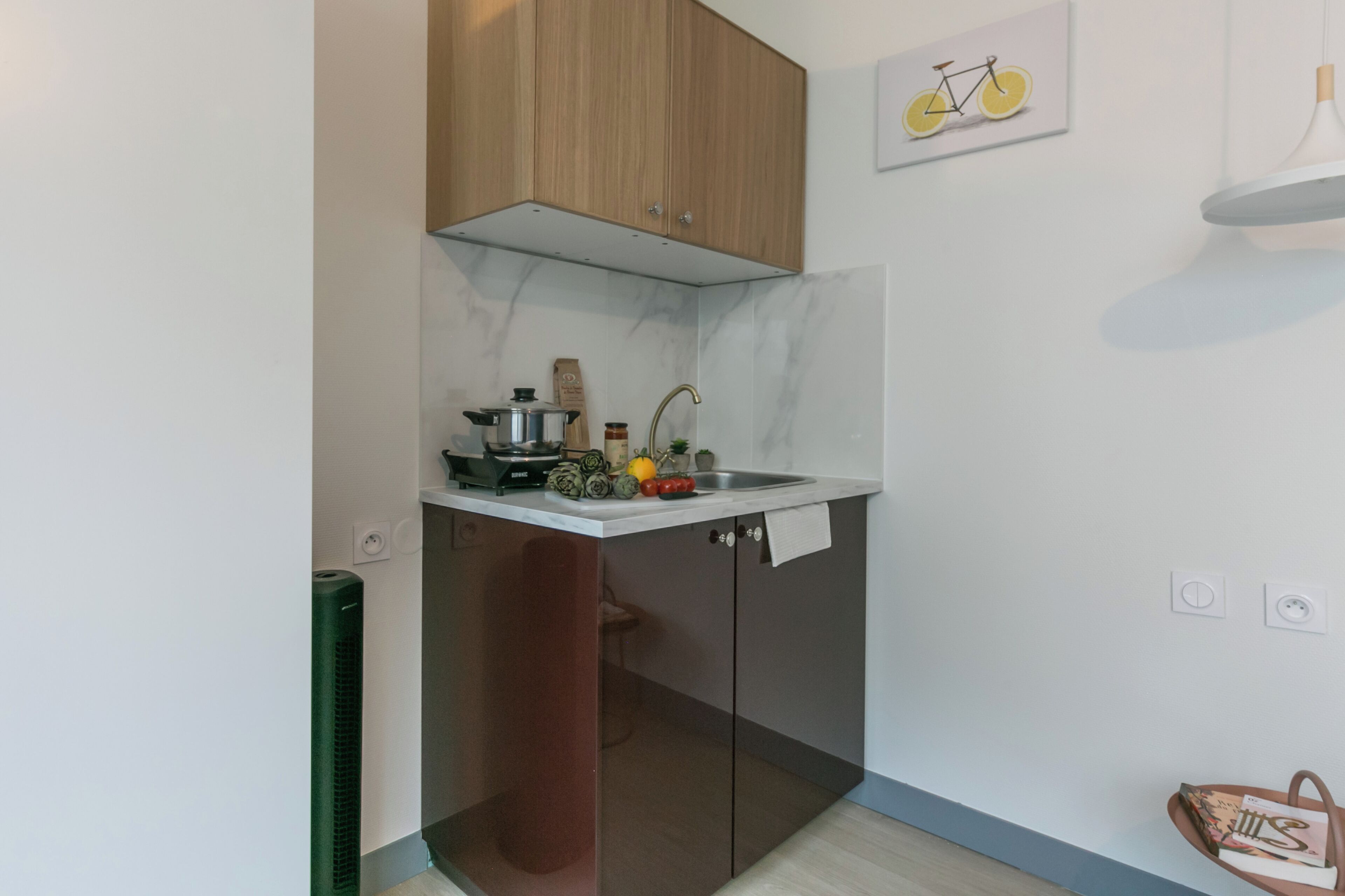 A compact kitchen with a built-in stove, a sink, and wooden cabinets.