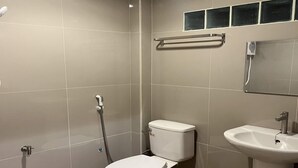 A bathroom with a toilet, sink, and shower.