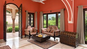 A room with two floral-patterned sofas, a coffee table, and a decorative trunk.