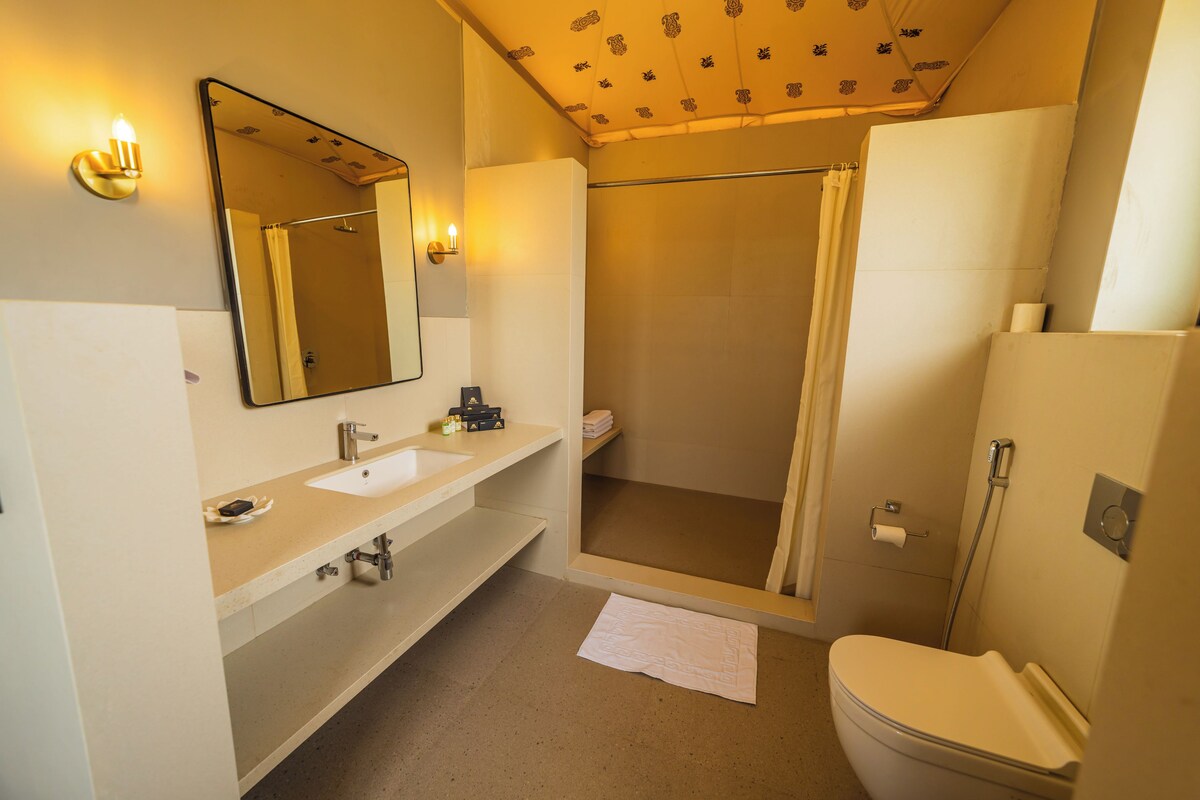 A bathroom with a sink, mirror, toilet, and shower.