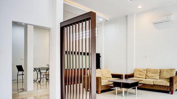 Un salon moderne avec un canapé, une table basse et un paravent décoratif.