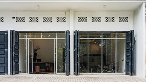 Une entrée d’immeuble avec des portes en verre et un portail métallique.
