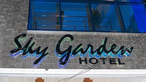 The exterior of Sky Garden Hotel with a prominent sign and a brick facade. - Sky Garden Hotel By Reddoorz (Roxas City)