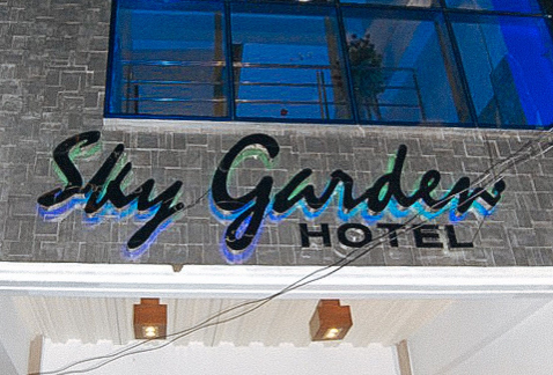 The exterior of Sky Garden Hotel with a prominent sign and a brick facade.
