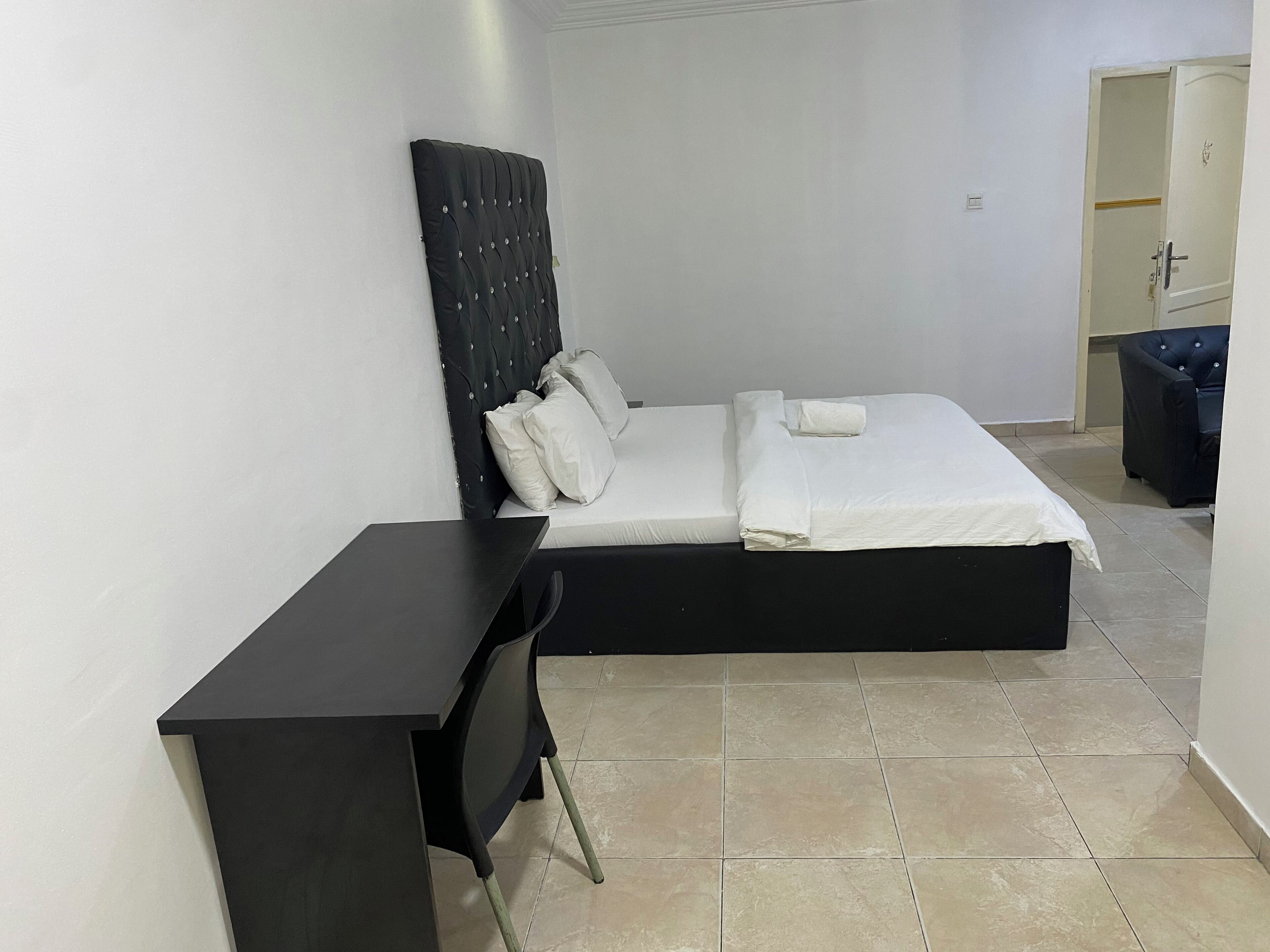 A bedroom with a bed, a desk, and a chair.