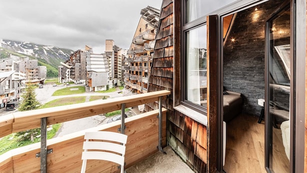 Een moderne hotelkamer met balkon en uitzicht op een bergachtig gebied.
