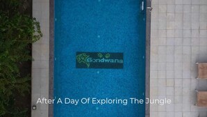 Une piscine avec un panneau indiquant « Gondwana » et un chemin bordé de carreaux à côté.