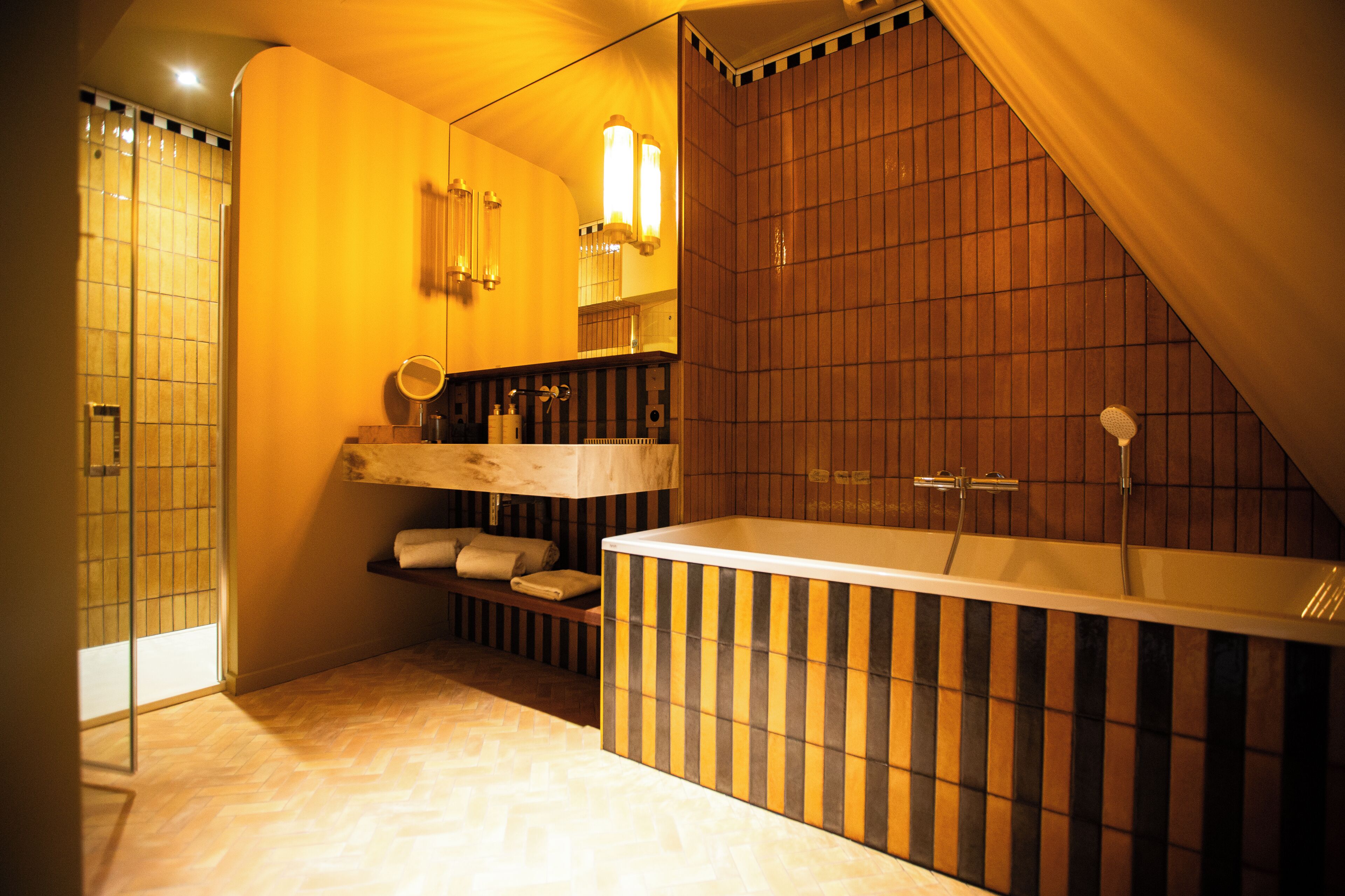A modern bathroom with a freestanding bathtub, a wooden vanity, and a mirror.