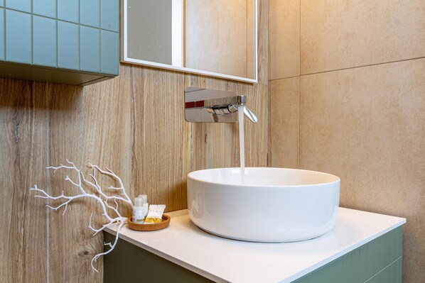 A bathroom with a white sink, a mirror, and a wooden wall.