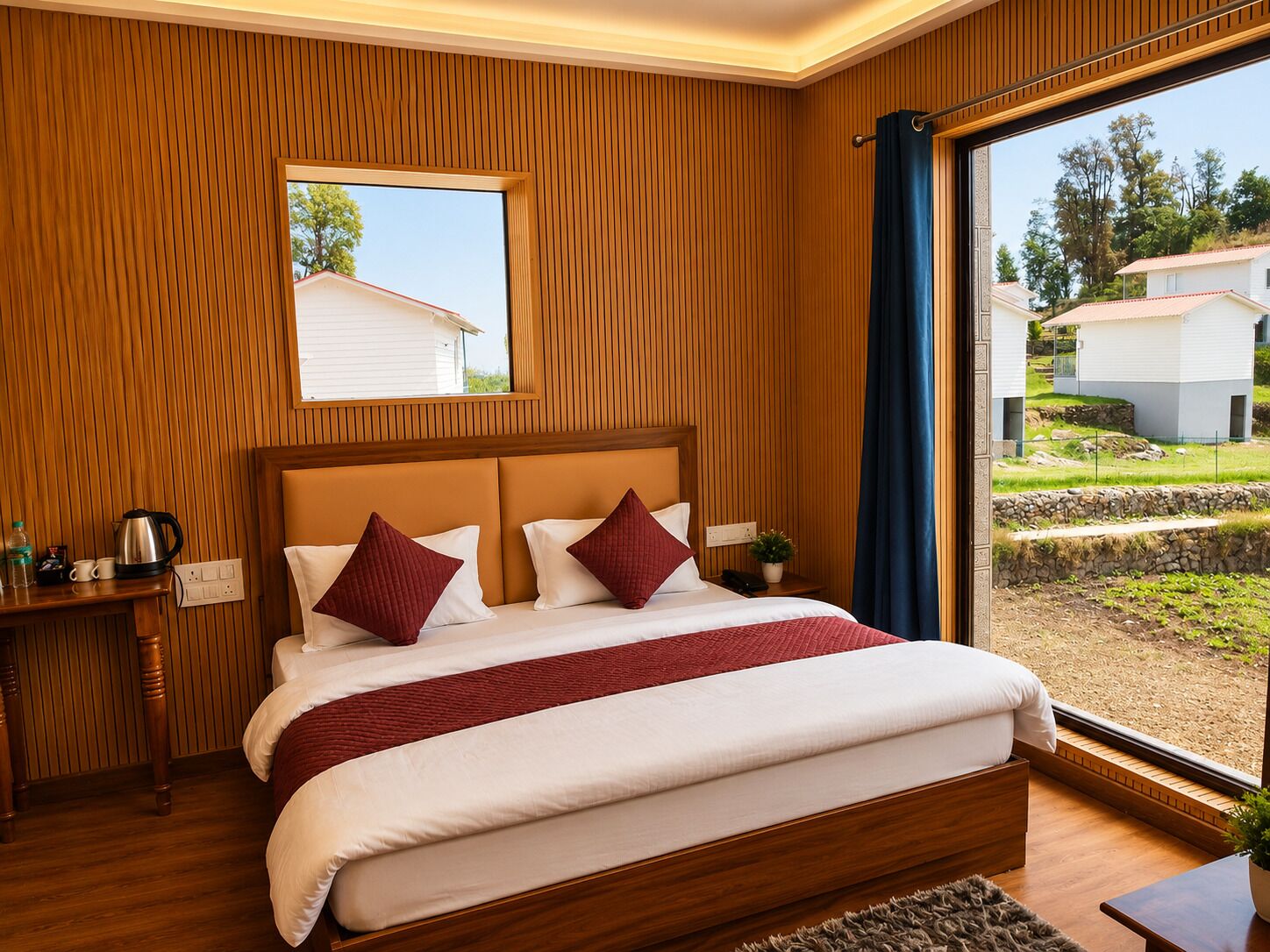 Una camera da letto con una testiera in legno, un'ampia finestra vista case, un comodino con un telefono e una pianta, e una coperta a letto rossa e bianca.