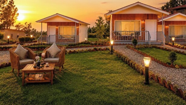 A bungalow-style hotel with a patio, outdoor seating, and a well-maintained garden. - The Grand View Resort (Dehradun)