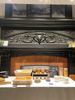 A breakfast buffet with bread, pastries, and condiments.