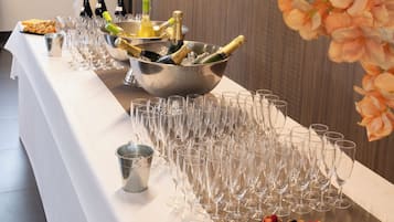 A buffet table with champagne bottles, glasses, and a variety of desserts.