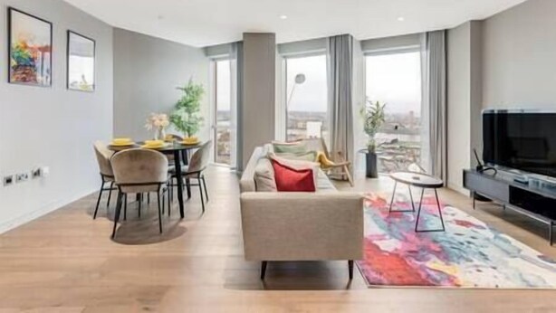 Un salon moderne comprenant un canapé, une table basse et un coin repas avec des chaises et une table.