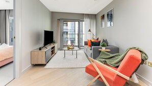 A modern living room with a sofa, a TV, a coffee table, and a large window. - ShyPen One - Bedroom APT (London)