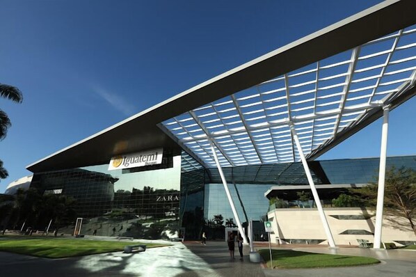 A modern building with a glass facade and a large overhang. - Flat Santa Maria (Fortaleza)