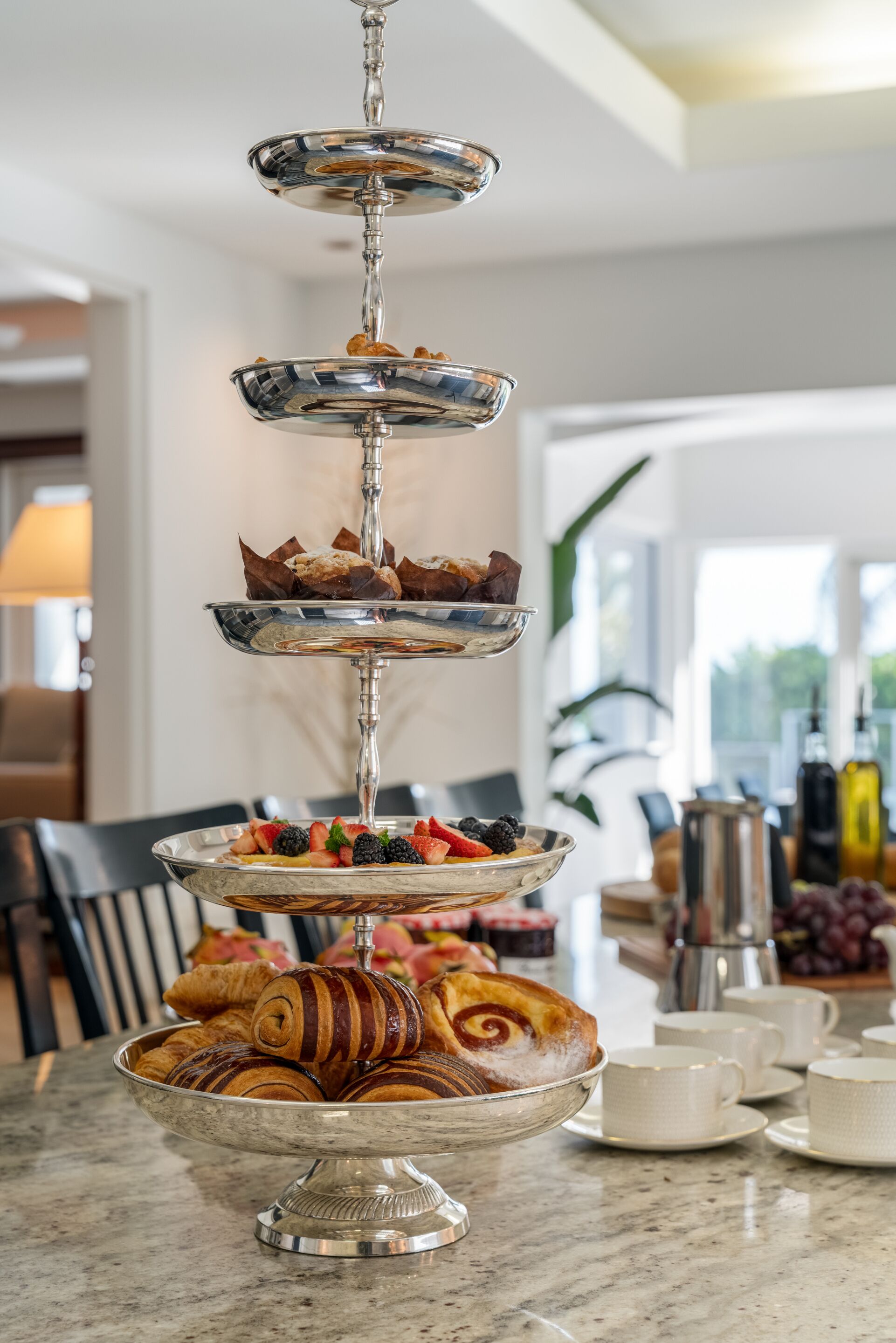 Eine mehrstufige Dessertvitrine mit Gebäck und Früchten.