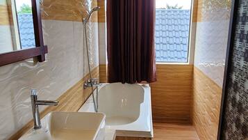 A modern bathroom with a large sink, a bathtub, and a shower. There is a window with curtains and a ceiling-mounted air purifier.