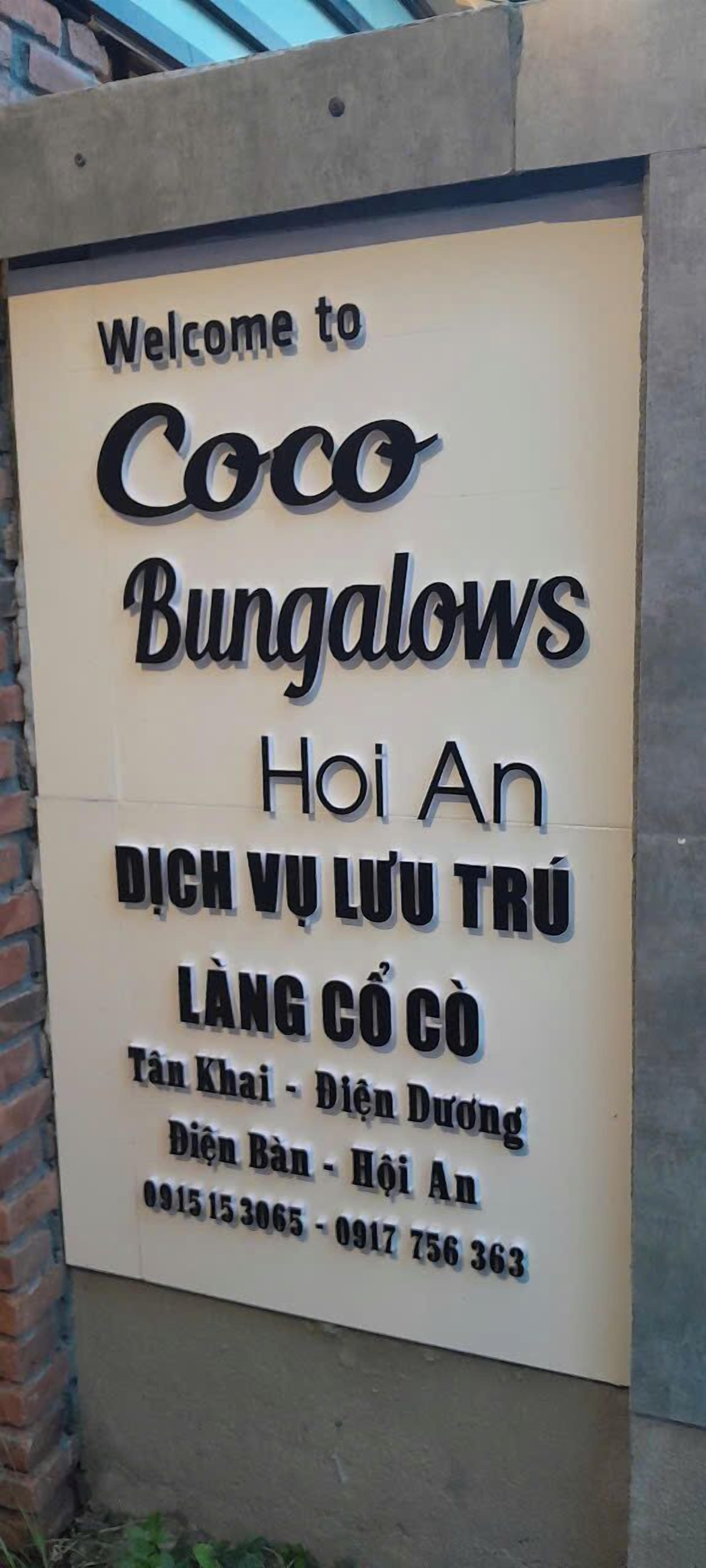 A welcome sign for Coco Bungalows in Hanoi, Vietnam, including contact information and directions.