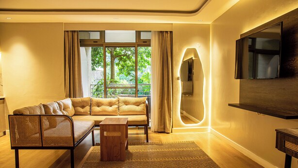 A modern living room with a sofa, a coffee table, and a TV mounted on the wall. - Lion Villas (Nairobi)