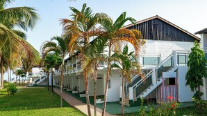 Een resort met een wit gebouw, palmbomen en een trap naar de ingang.