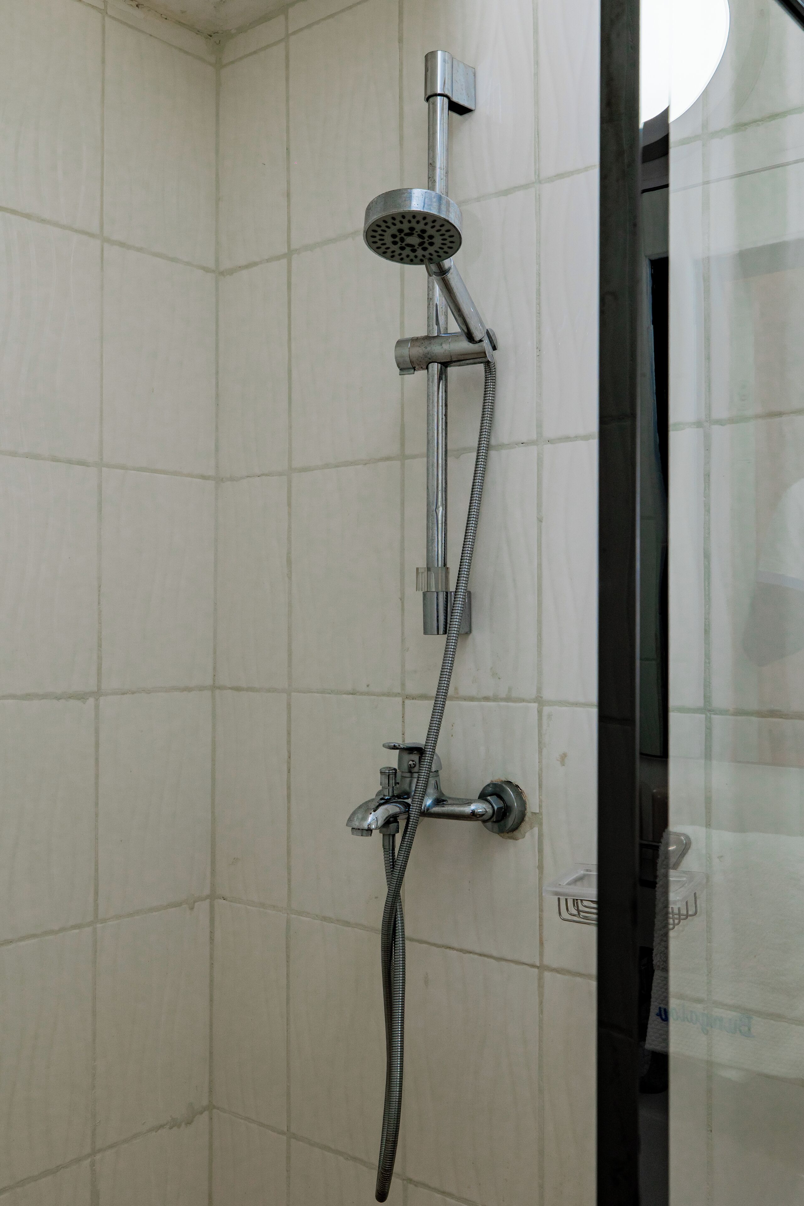 Eine Dusche mit Handbrause und Wandarmatur.
