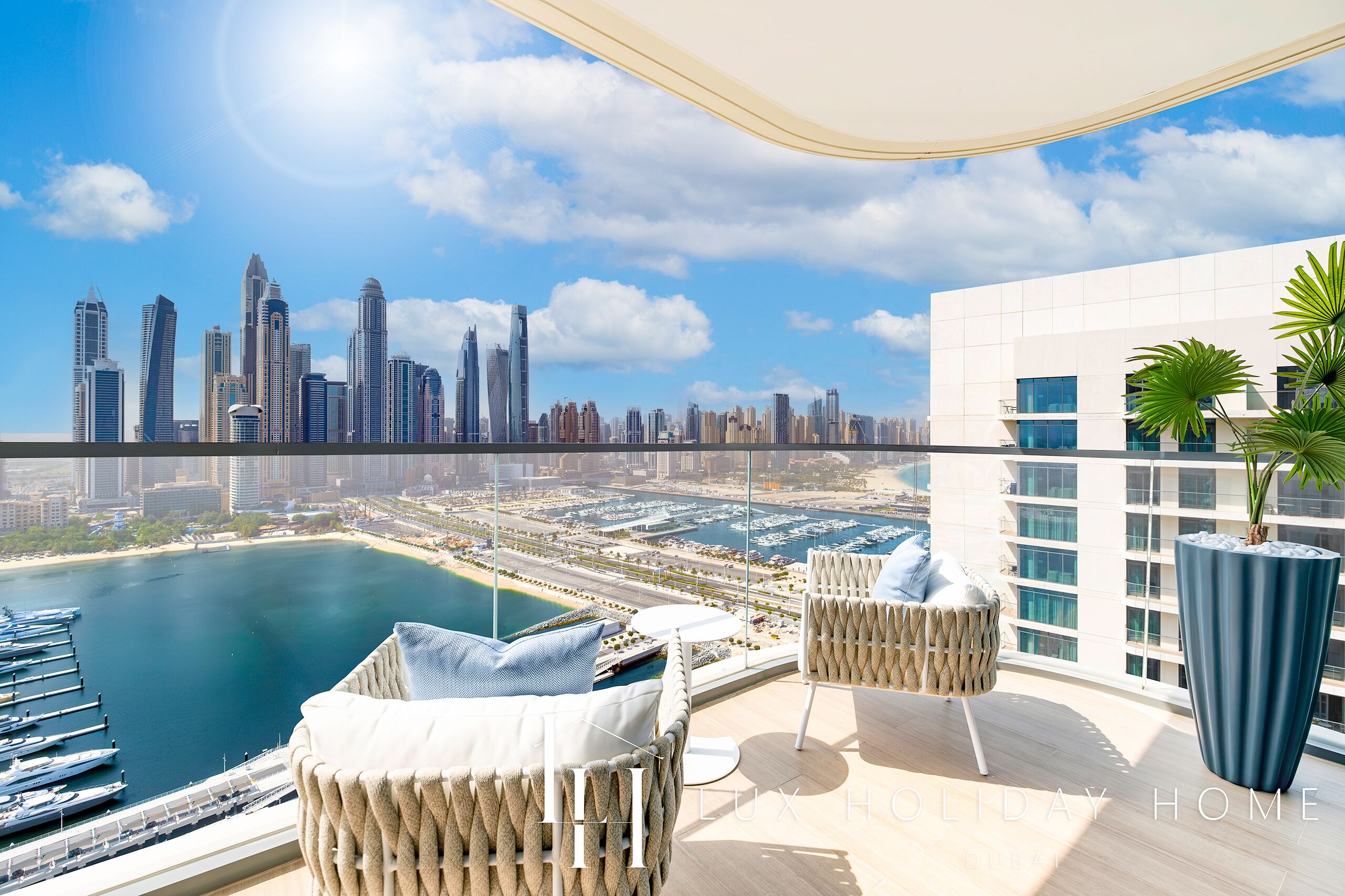 A balcony with a city skyline view, a pool, and modern outdoor furniture.