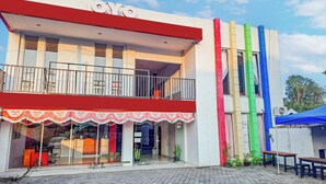 Un bâtiment doté d’un auvent rouge, d’un balcon et d’une façade aux couleurs vives.