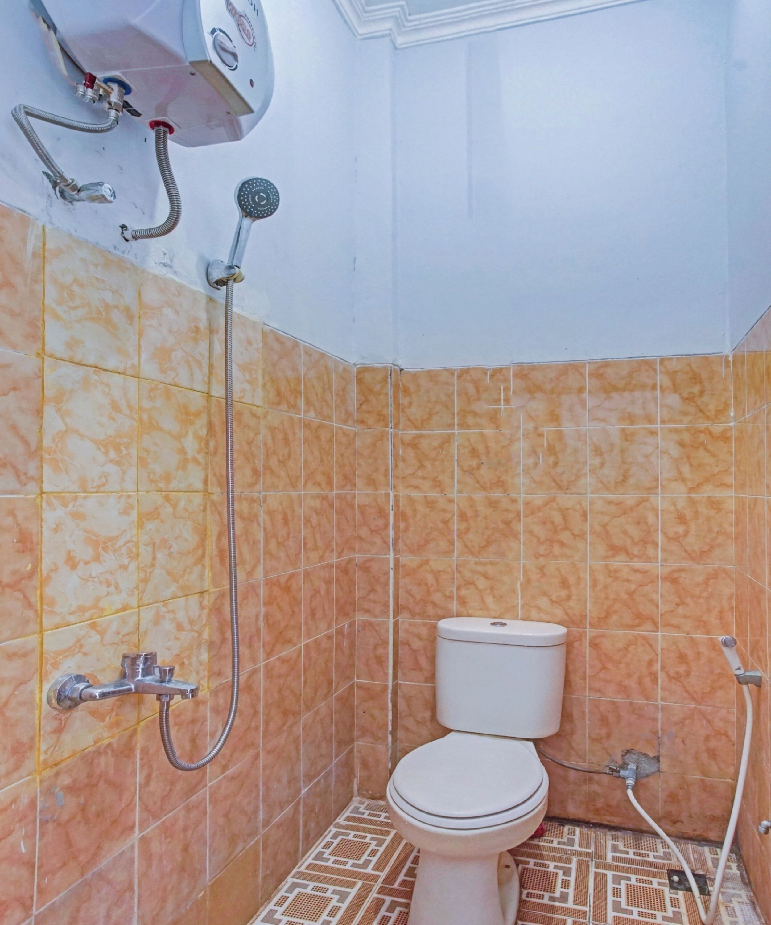 A bathroom with a toilet, a shower, and a wall-mounted water heater.