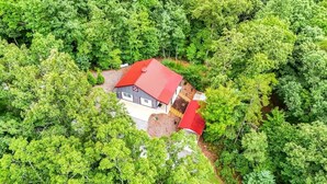 Ein Haus, umgeben von dichtem, grünen Wald.