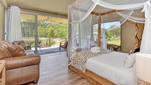 Une chambre à coucher avec un lit à baldaquin, un canapé et une vue sur l’extérieur.