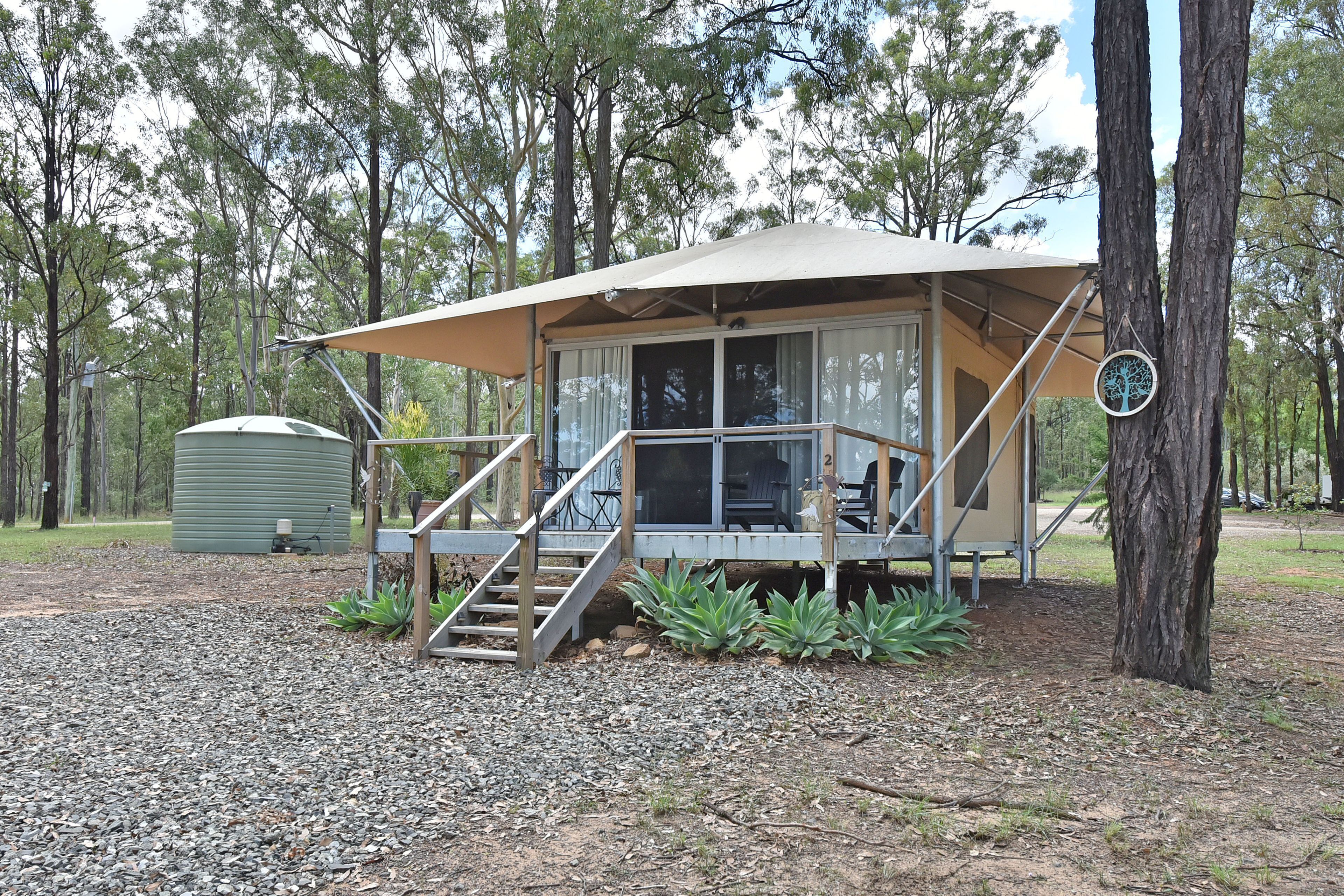 A small, single-story cabin with a covered porch and a staircase leading to the entrance.