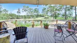 A wooden deck with a view of a pond and trees, featuring a table and chairs. - Verdelho - Pokolbin Glamping eco-friendly Sleeps 2 (Pokolbin)