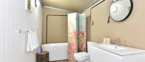 Une salle de bain avec une baignoire, des toilettes et un lavabo.
