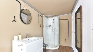 A modern bathroom with a white bathtub, a glass shower enclosure, and a round mirror on the wall. - Verdelho - Pokolbin Glamping eco-friendly Sleeps 2 (Pokolbin)