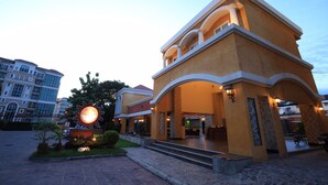A resort with a large sun-shaped sign, a covered outdoor area, and a stone-paved entrance. - Grand Smile Wellness Resort (Pattaya)
