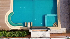 A rectangular swimming pool with a tiled floor and a curved edge. - Grand Smile Wellness Resort (Pattaya)