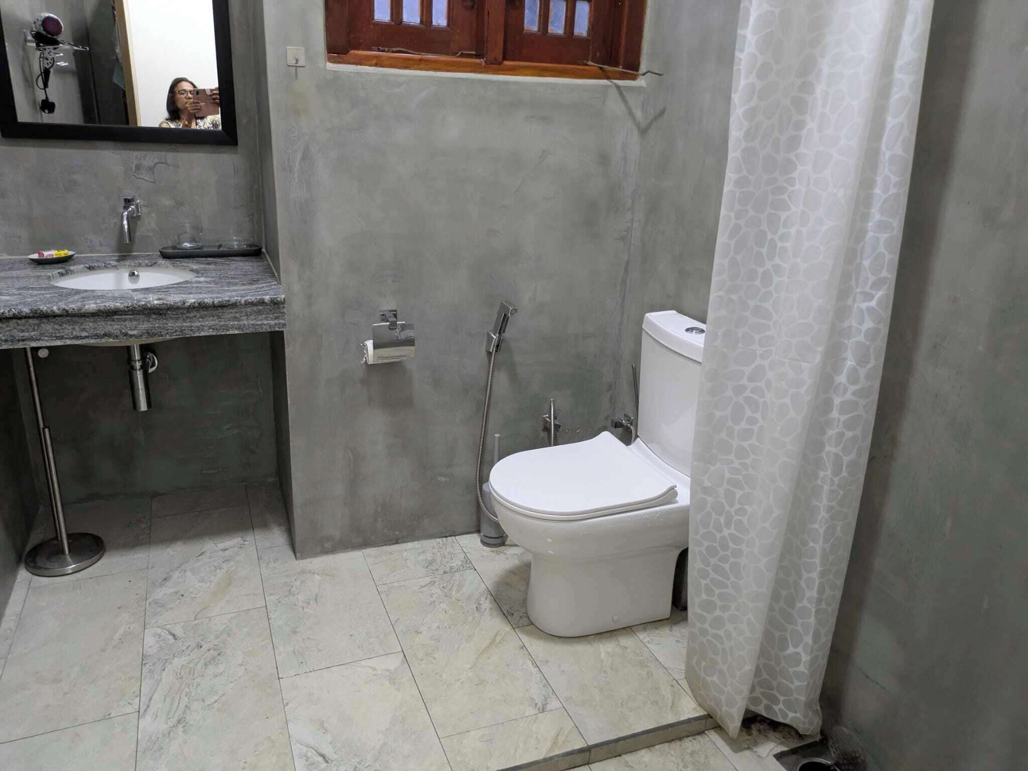 Un baño con lavamanos, inodoro y ducha.