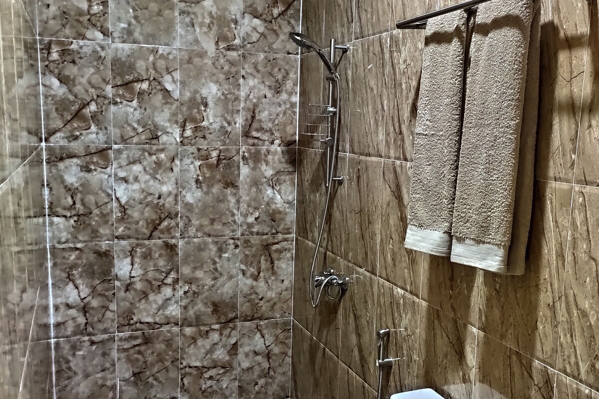 Ein Badezimmer mit Dusche, Toilette und Handtuchhalter.