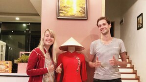 A reception area with a mannequin in a red dress and a conical hat, a staircase, and a framed picture on the wall. - Room in House - Trang An Ao Dai Homestay - Double Room With Field View and Bathtub - Hoa Lu Room (Hoa Lu)
