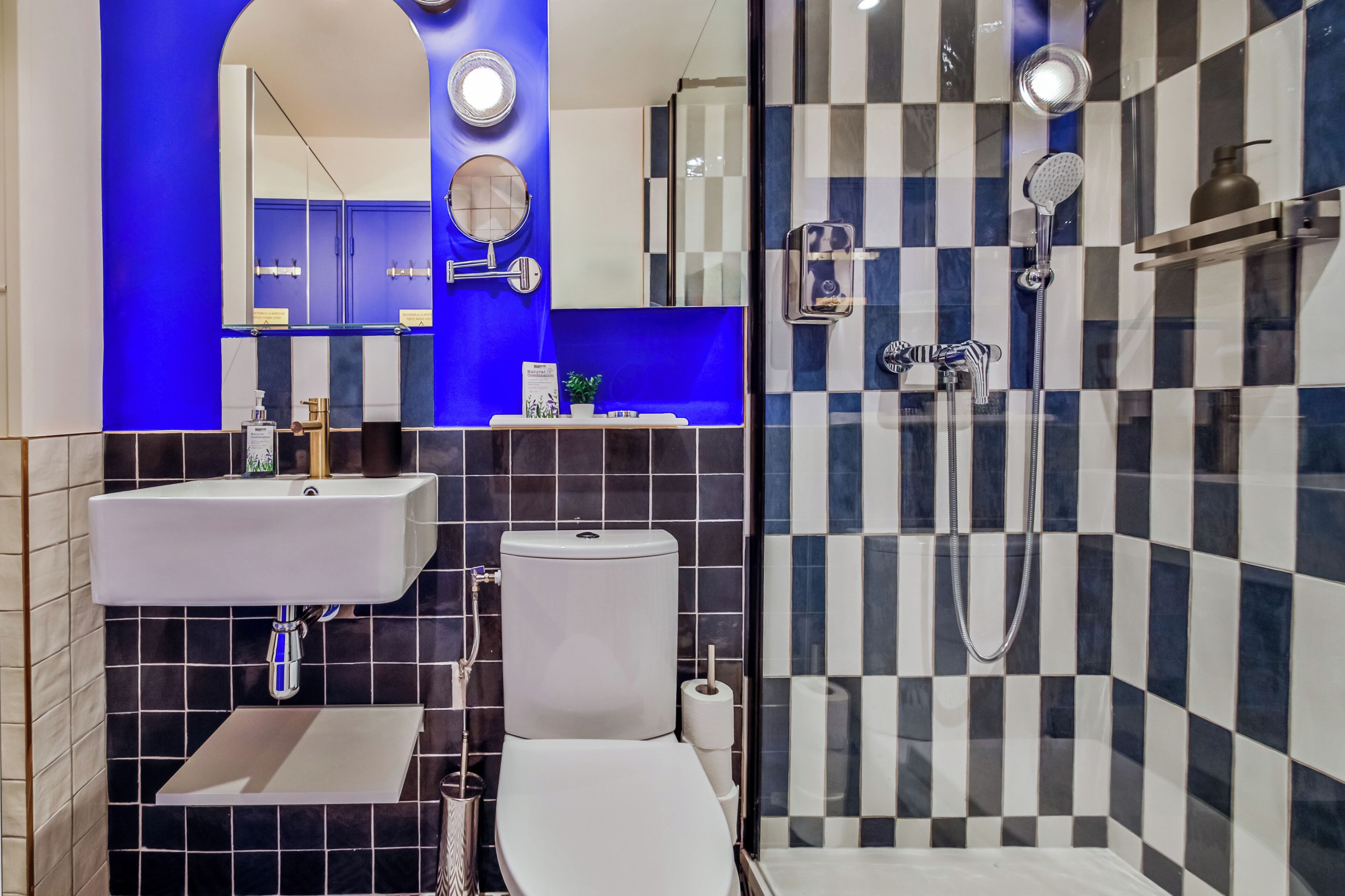 A modern bathroom with a white sink, toilet, and shower.