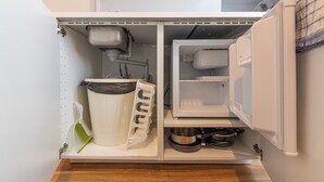 A compact kitchen with a built-in refrigerator, a coffee maker, and a sink. - WS Hôtel de Ville - Musée Pompidou (Paris)