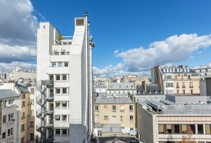 Un edificio de gran altura con varios balcones y una vista despejada del paisaje urbano circundante.