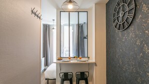 A modern bathroom with a large mirror, a clock, and a window with curtains. - WS Opéra - Rossini (Paris)