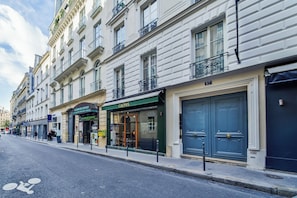 Vista de la calle con una hilera de edificios, incluyendo un restaurante llamado 'CAEPUS' y otro llamado 'COUPE DU PONT'.