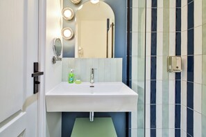 A bathroom with a white sink, a mirror, and a lighted vanity. - WS Opéra - Châteaudun (Paris)