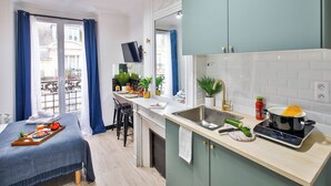 A modern kitchen with a sink, stove, and dining area. - WS Tour Eiffel - Laos (Paris)