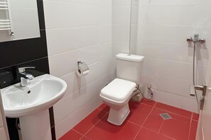A small bathroom with a white sink, toilet, and shower. - Korte Hotel Sleeps 14 With Courtyard (Mestia)